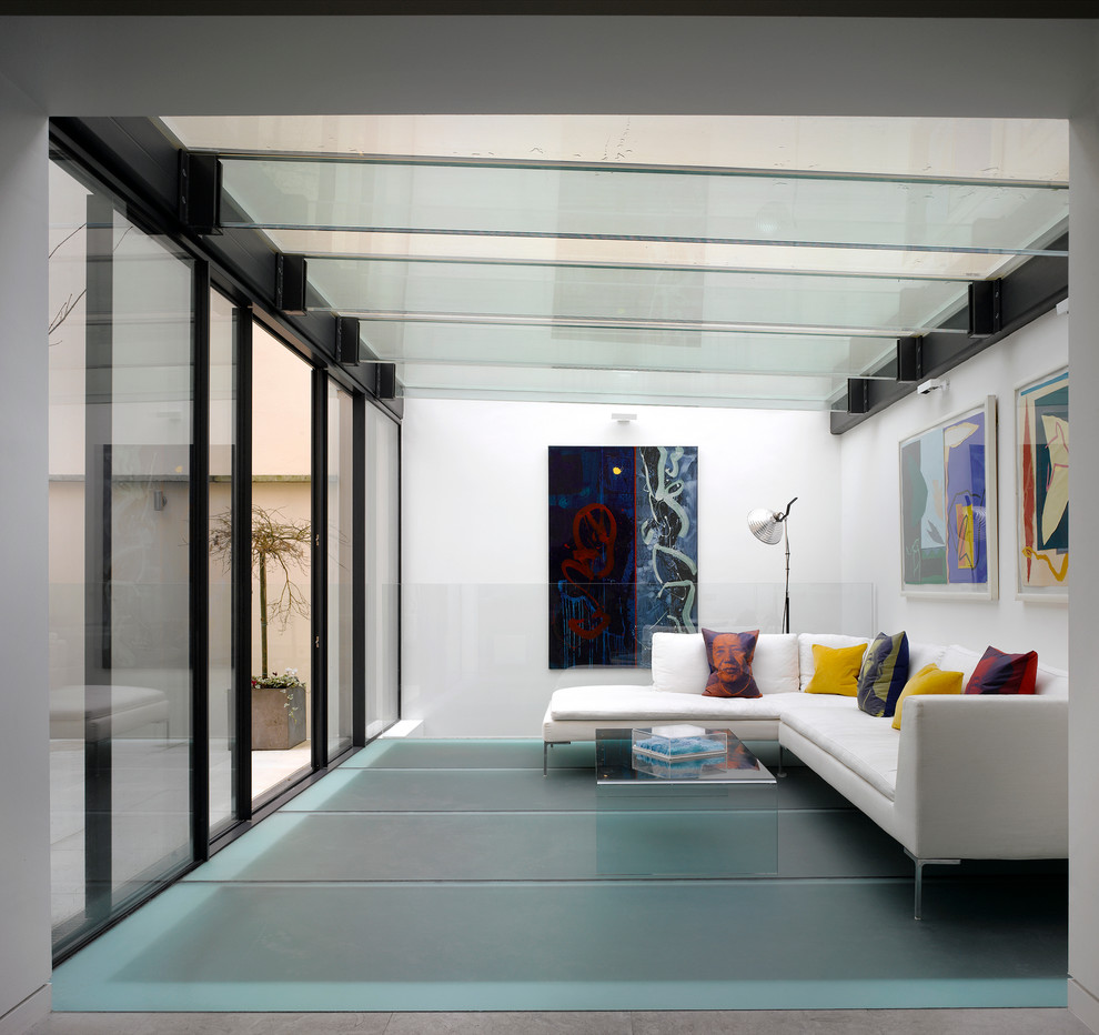 This is an example of a contemporary sunroom in London with no fireplace, a glass ceiling and turquoise floor.