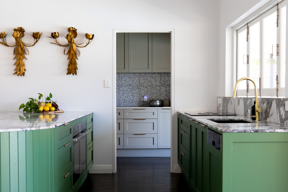 Inspiration for a large modern galley kitchen pantry in Adelaide with an undermount sink, shaker cabinets, green cabinets, marble benchtops, multi-coloured splashback, marble splashback, black appliances, painted wood floors, brown floor and multi-coloured benchtop.
