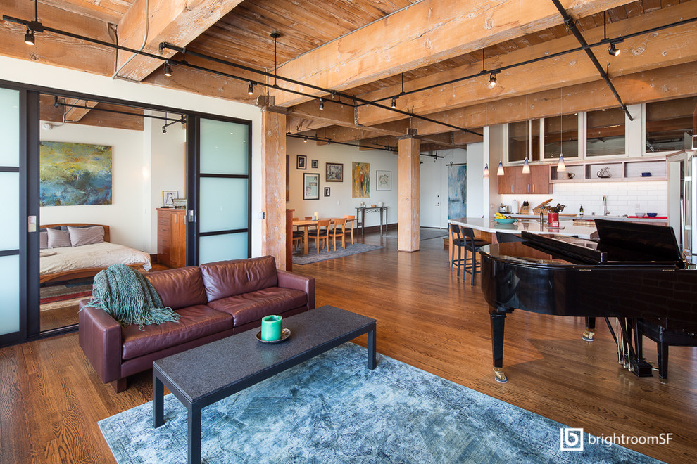 Photo of a large industrial open concept living room in San Francisco with white walls.