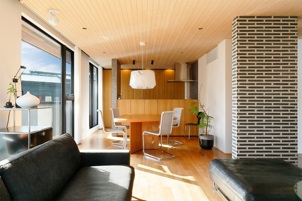 Стильный дизайн: гостиная-столовая в стиле модернизм с белыми стенами, светлым паркетным полом и коричневым полом - последний тренд