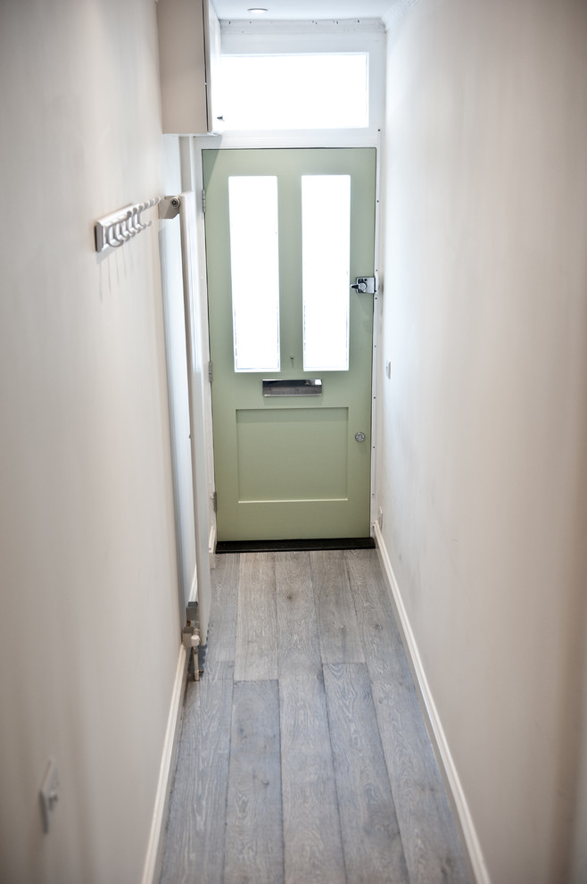 Large contemporary hallway in London with beige walls and medium hardwood floors.