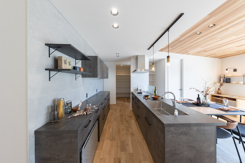 Idéer för att renovera ett orientaliskt grå grått kök, med en undermonterad diskho, luckor med profilerade fronter, grå skåp, laminatbänkskiva, grått stänkskydd, mellanmörkt trägolv, en halv köksö och brunt golv