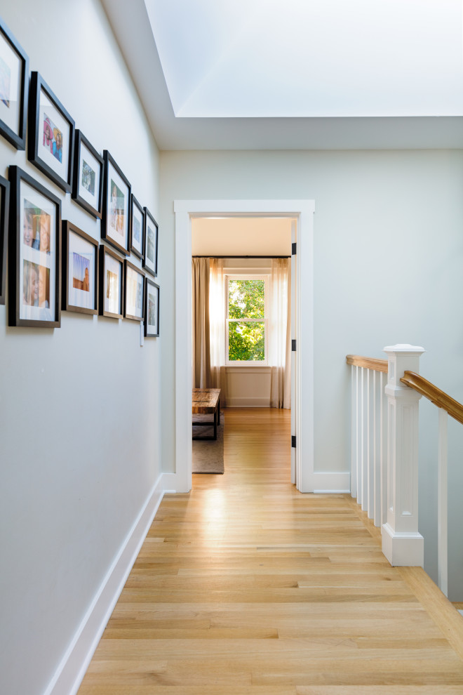 This is an example of a mid-sized traditional hallway in Seattle with green walls and light hardwood floors.