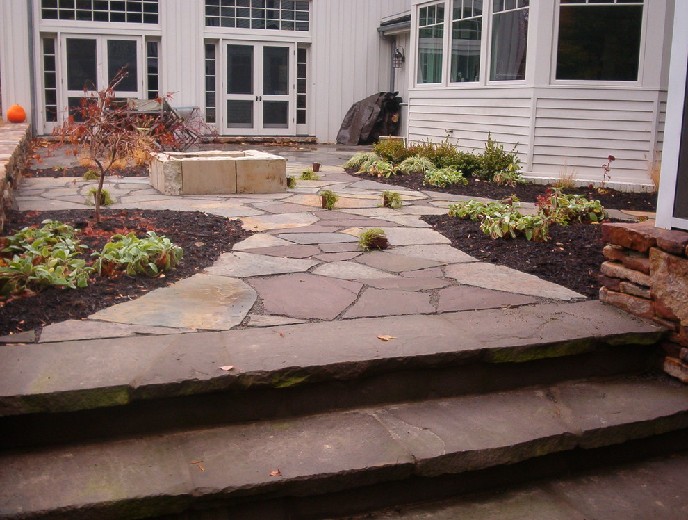 Inspiration for a small traditional backyard garden in Other with natural stone pavers.