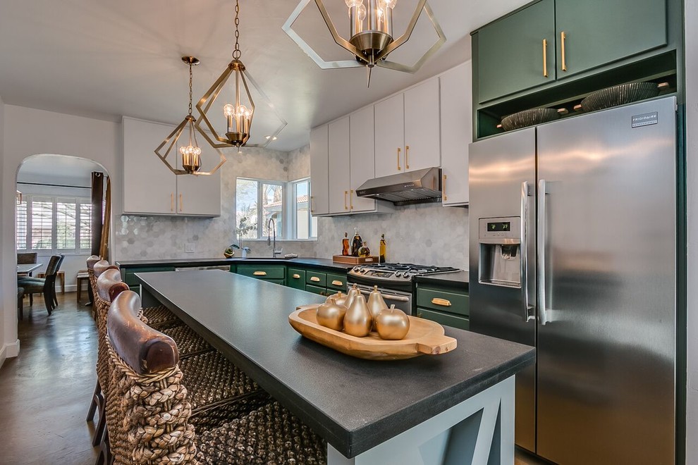 Mid-sized transitional l-shaped separate kitchen in Phoenix with an undermount sink, flat-panel cabinets, green cabinets, grey splashback, marble splashback, stainless steel appliances, concrete floors, with island and brown floor.