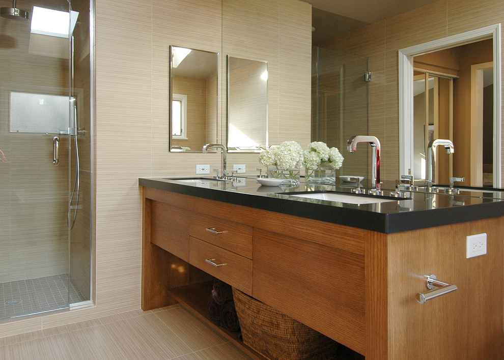 Mid-sized contemporary master bathroom in Boston with an undermount sink, flat-panel cabinets, an alcove shower, beige tile, porcelain tile, beige walls, porcelain floors, solid surface benchtops, light wood cabinets, beige floor and a hinged shower door.
