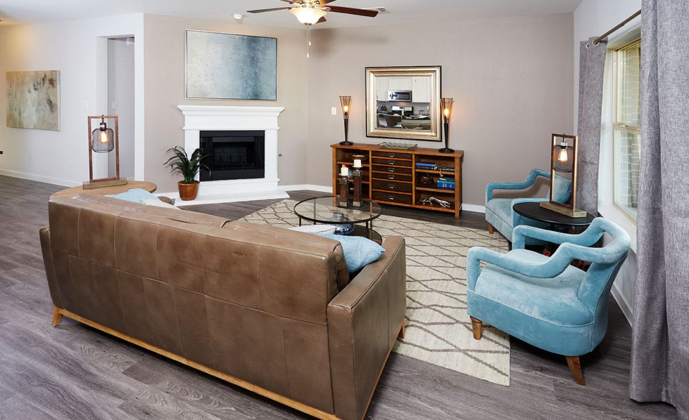 Modelo de sala de estar abierta contemporánea con paredes grises, suelo laminado, todas las chimeneas, marco de chimenea de madera y suelo gris