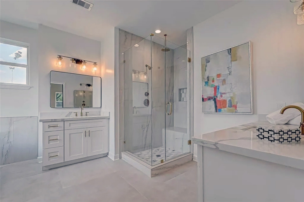 Example of a mid-sized master gray tile and marble tile mosaic tile floor, gray floor and double-sink freestanding bathtub design with white cabinets, white walls, marble countertops, a hinged shower door, white countertops and a built-in vanity