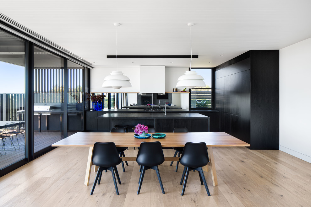 Design ideas for a contemporary kitchen/dining combo in Melbourne with white walls, light hardwood floors and beige floor.