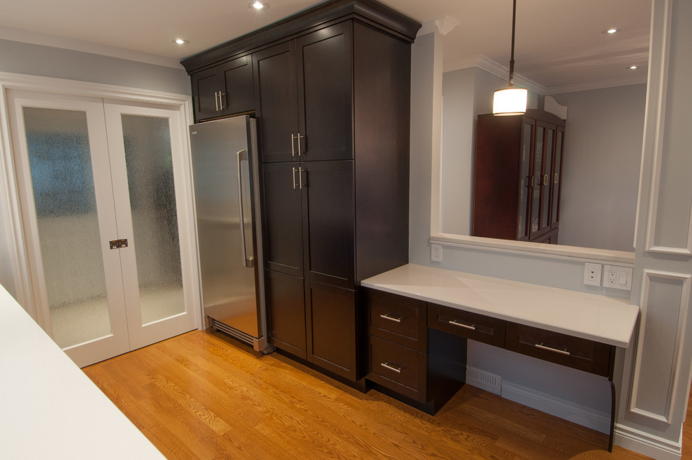 Large transitional galley light wood floor enclosed kitchen photo in Toronto with a single-bowl sink, shaker cabinets, dark wood cabinets, quartzite countertops, beige backsplash, stone tile backsplash, stainless steel appliances and an island