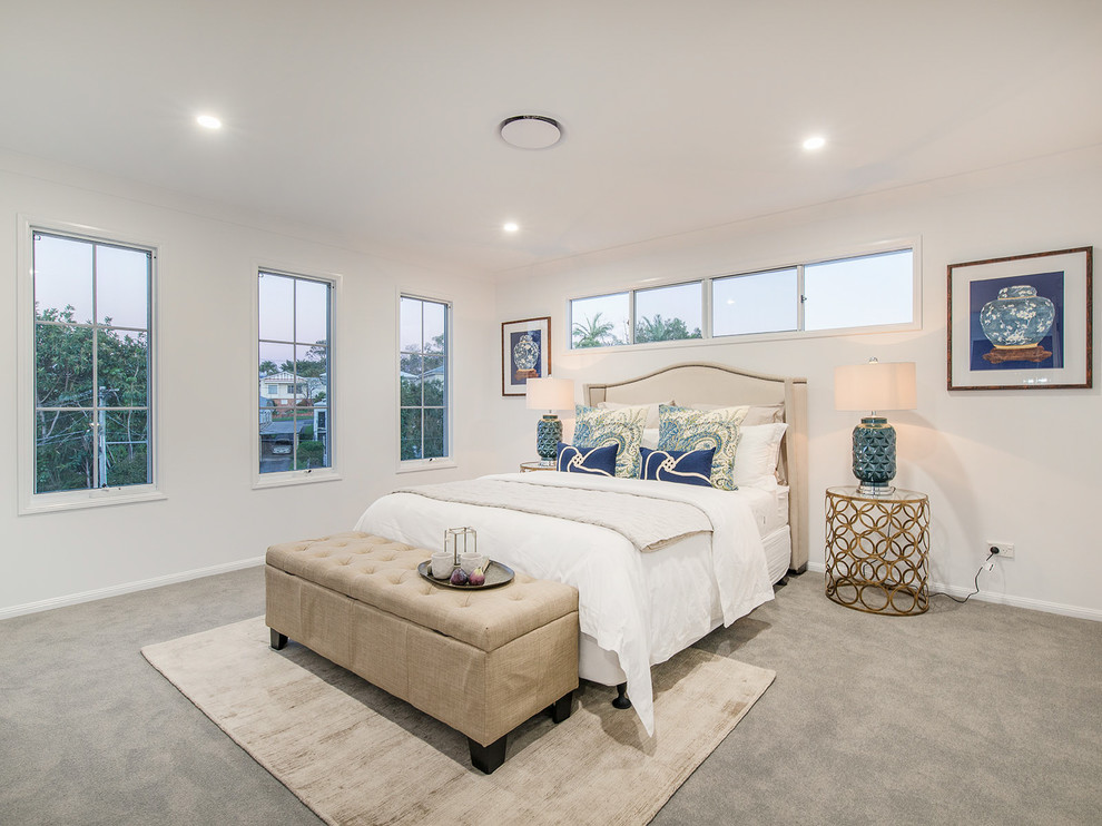 This is an example of a mid-sized beach style master bedroom in Brisbane with white walls, carpet and grey floor.