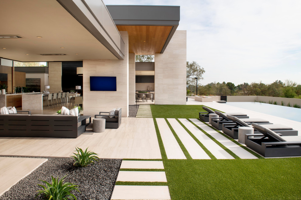 Cette photo montre une grande terrasse arrière tendance avec un foyer extérieur, du carrelage et aucune couverture.