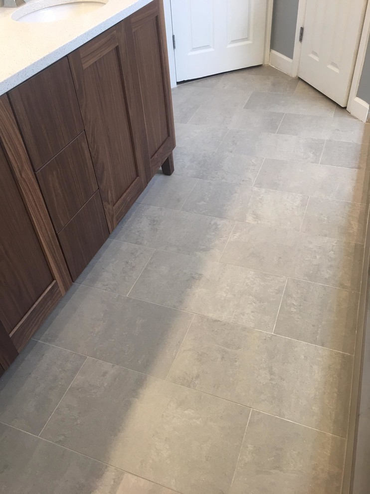 Example of a mid-sized transitional master beige tile and porcelain tile porcelain tile doorless shower design in Raleigh with recessed-panel cabinets, medium tone wood cabinets, gray walls, an undermount sink and quartz countertops