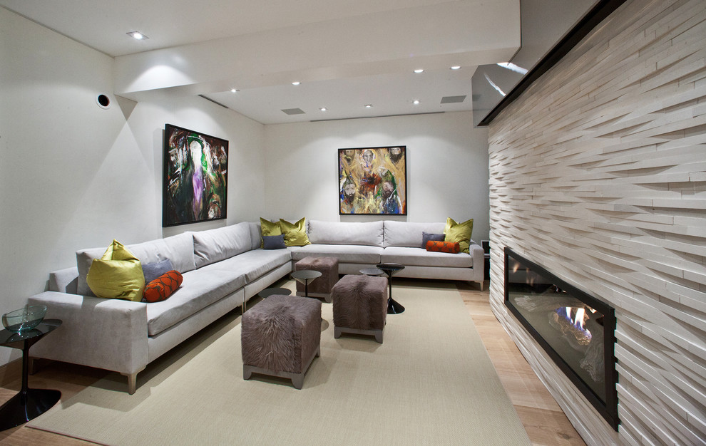 Photo of a large contemporary look-out basement in Denver with white walls, light hardwood floors, a stone fireplace surround and a ribbon fireplace.