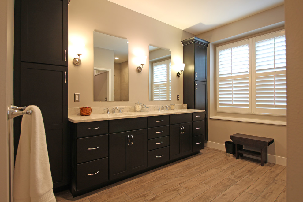 Photo of a large transitional master bathroom in Detroit with shaker cabinets, black cabinets, an open shower, a two-piece toilet, gray tile, porcelain tile, beige walls, porcelain floors, an undermount sink, engineered quartz benchtops, beige floor, an open shower and beige benchtops.