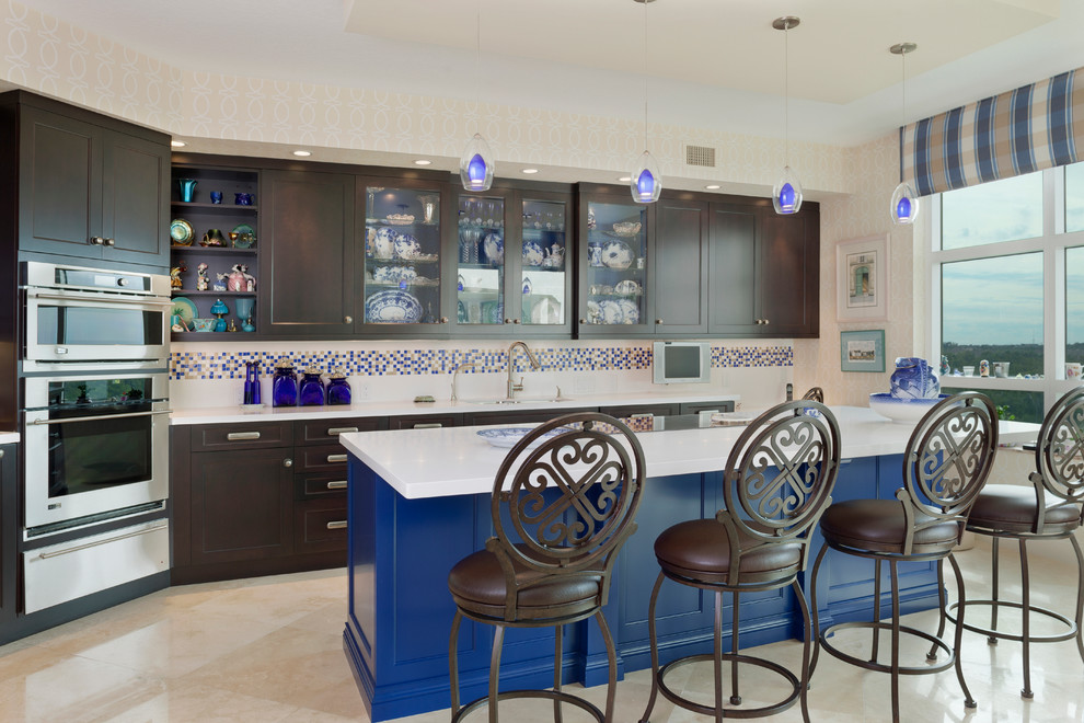 Mid-sized transitional l-shaped porcelain tile and beige floor eat-in kitchen photo in Miami with an undermount sink, recessed-panel cabinets, dark wood cabinets, solid surface countertops, multicolored backsplash, porcelain backsplash, stainless steel appliances, an island and white countertops