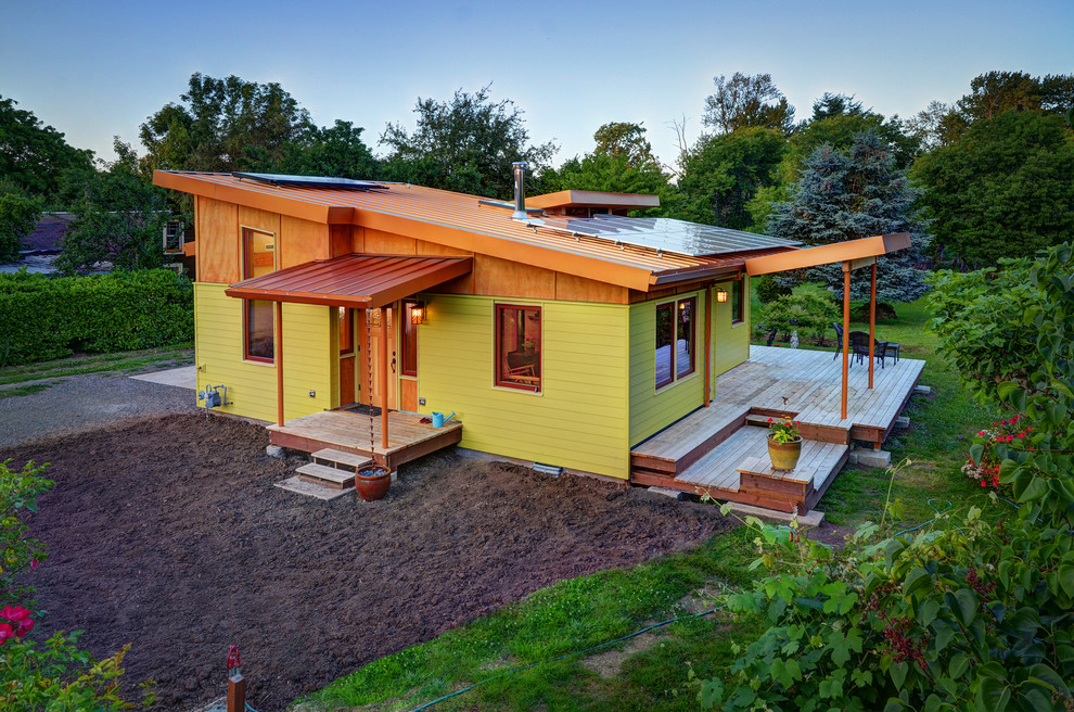 This is an example of a contemporary one-storey yellow exterior in Other with a shed roof.