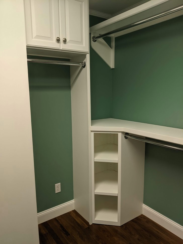 Exempel på ett litet modernt walk-in-closet, med luckor med upphöjd panel, vita skåp, mörkt trägolv och brunt golv