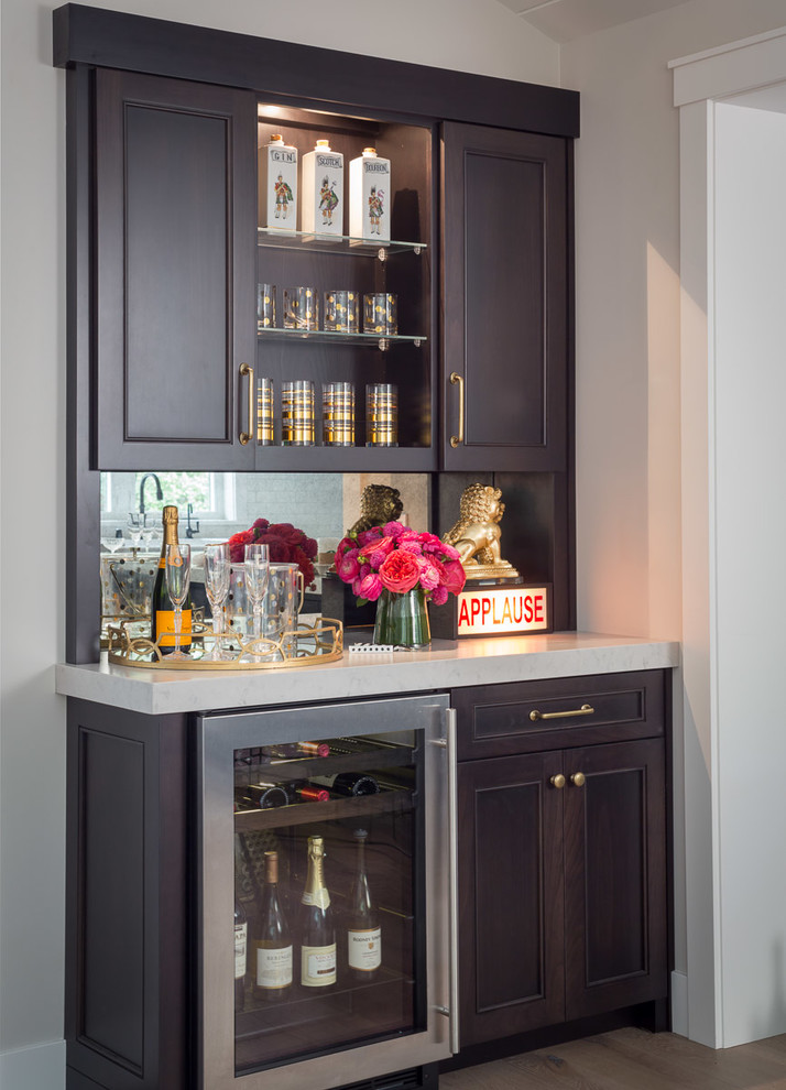 Inspiration for a mid-sized transitional single-wall wet bar in San Francisco with dark wood cabinets, mirror splashback, dark hardwood floors, marble benchtops, multi-coloured splashback, brown floor and recessed-panel cabinets.
