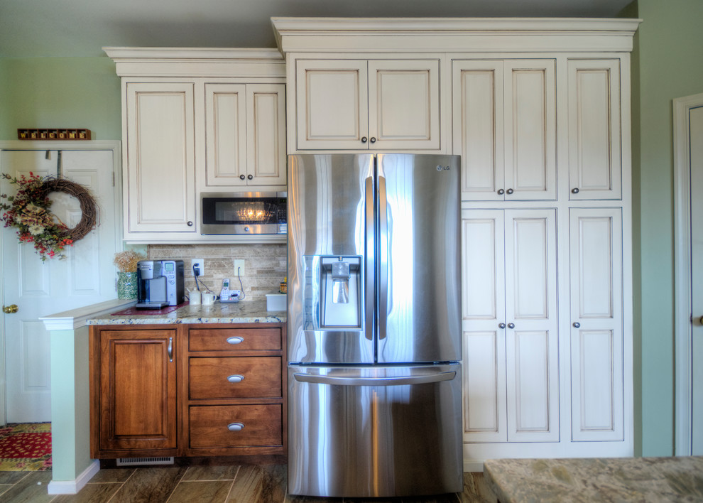 Photo of a mid-sized country l-shaped kitchen pantry in Richmond with a farmhouse sink, beaded inset cabinets, white cabinets, granite benchtops, beige splashback, stone tile splashback, stainless steel appliances and with island.