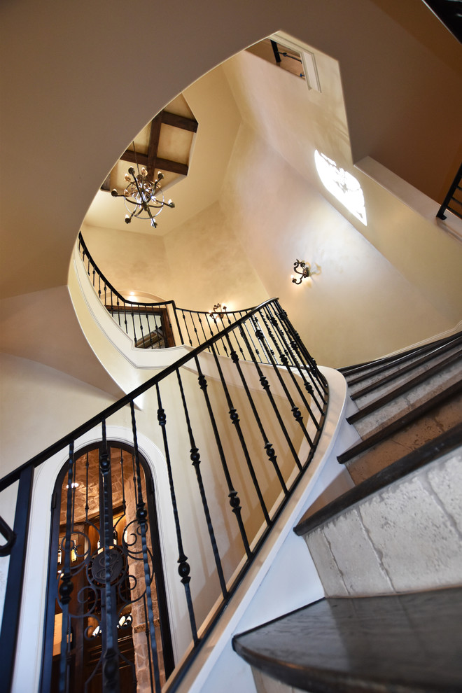 Inspiration for a huge mediterranean wooden curved staircase remodel in Houston with tile risers
