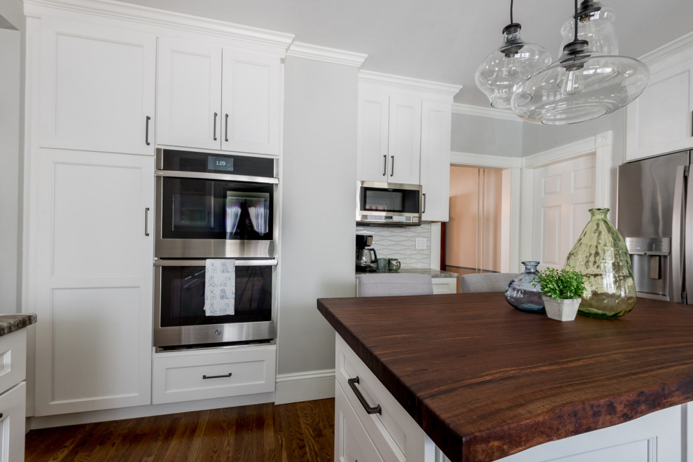 Eat-in kitchen - mid-sized transitional u-shaped medium tone wood floor and brown floor eat-in kitchen idea in Boston with an undermount sink, shaker cabinets, white cabinets, quartzite countertops, gray backsplash, ceramic backsplash, stainless steel appliances, an island and multicolored countertops