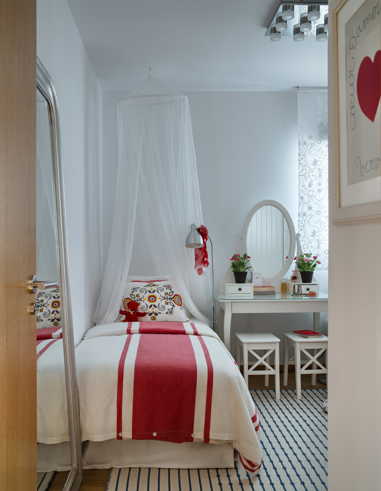 Design ideas for a mid-sized transitional gender-neutral kids' bedroom for kids 4-10 years old in Malaga with white walls.