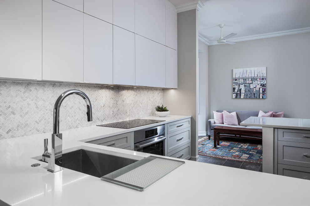 Inspiration for a small contemporary l-shaped open plan kitchen in Miami with an undermount sink, shaker cabinets, white cabinets, quartz benchtops, white splashback, marble splashback, stainless steel appliances, slate floors, a peninsula, grey floor and white benchtop.