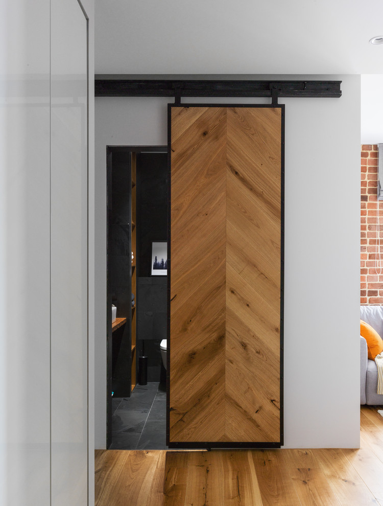 Inspiration for an industrial hallway in Moscow with white walls, medium hardwood floors and brown floor.