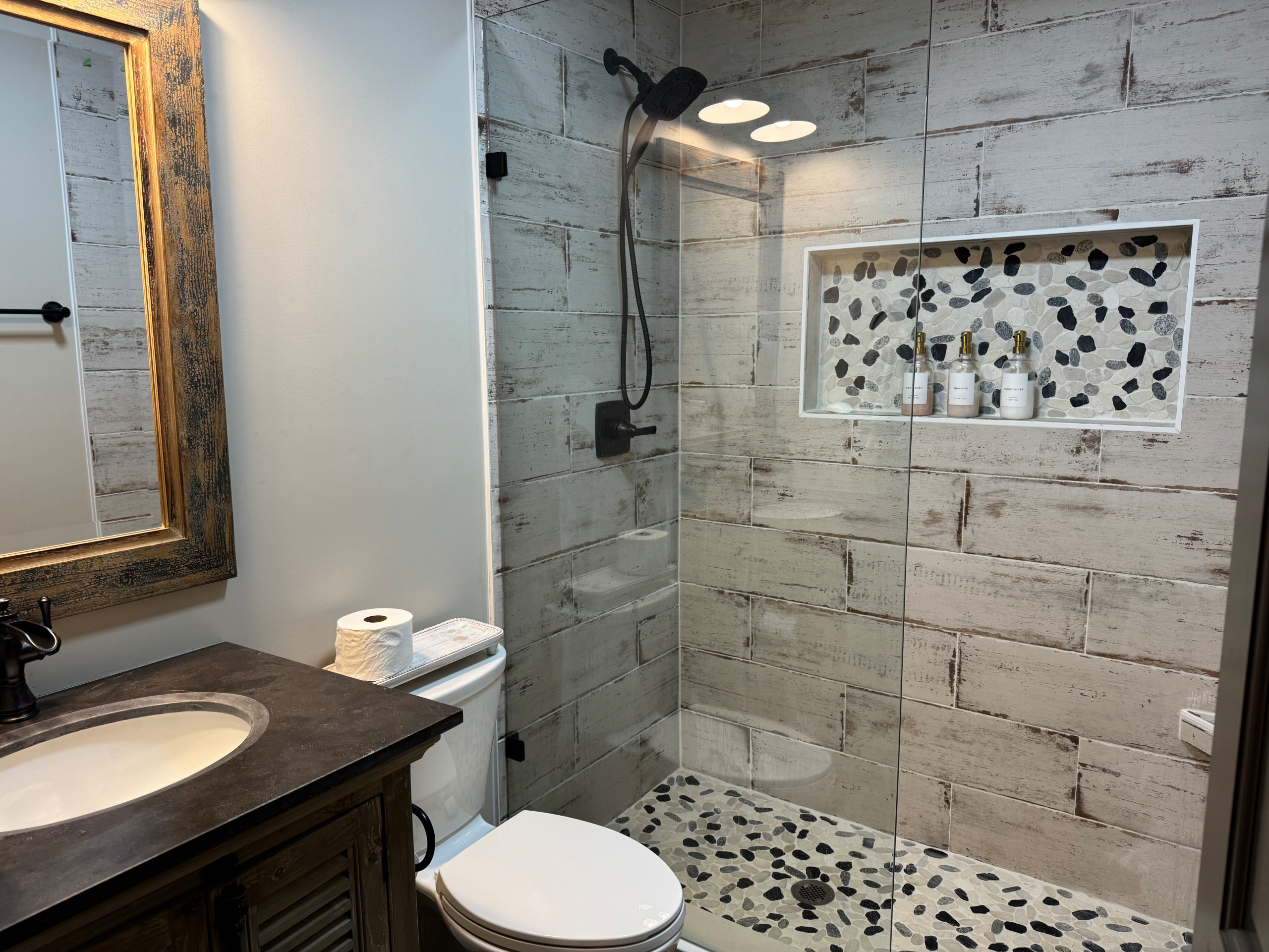 Rustic Farmhouse Bathroom Remodel with Wood-Look Tile and Pebble Shower Floor