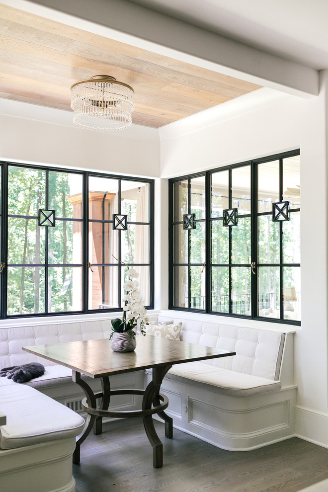 Example of a mid-sized transitional medium tone wood floor and brown floor enclosed dining room design in Atlanta with white walls and no fireplace