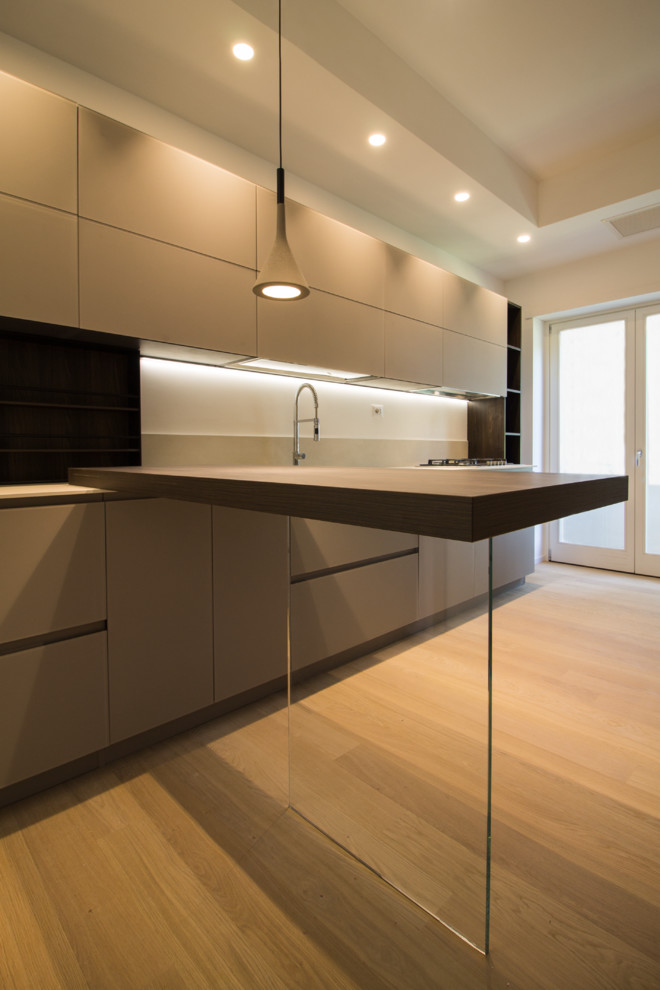 Photo of a mid-sized single-wall separate kitchen in Rome with an undermount sink, solid surface benchtops, beige splashback, porcelain splashback, stainless steel appliances, a peninsula and beige benchtop.