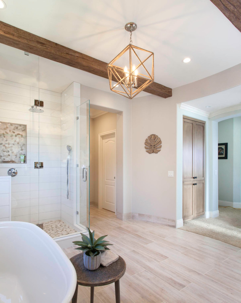 Photo of a large country master bathroom in Denver with recessed-panel cabinets, distressed cabinets, a freestanding tub, an open shower, a two-piece toilet, white tile, ceramic tile, white walls, porcelain floors, an undermount sink, engineered quartz benchtops, beige floor, a hinged shower door and white benchtops.