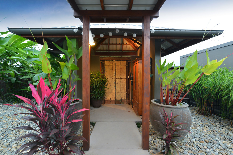 Design ideas for a tropical front door in Cairns with concrete floors, a double front door, a yellow front door and grey floor.