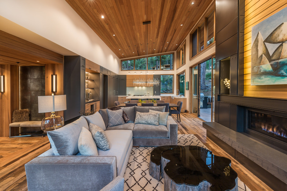 This is an example of a contemporary formal open concept living room in Sacramento with medium hardwood floors, a ribbon fireplace, no tv and brown floor.