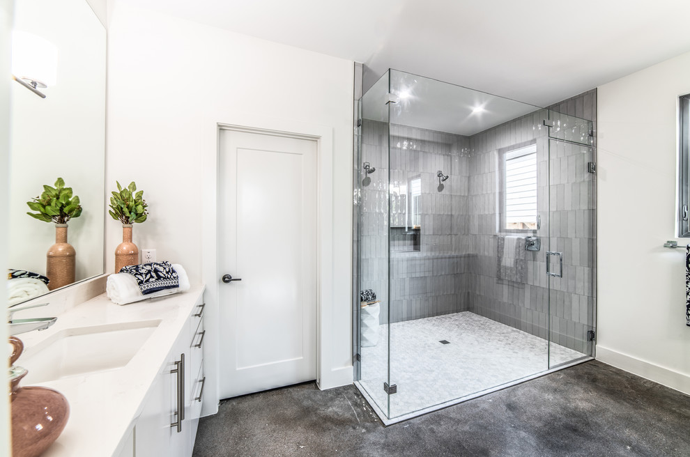 Contemporary master bathroom in Austin with flat-panel cabinets, white cabinets, a curbless shower, gray tile, subway tile, white walls, an undermount sink, grey floor, a hinged shower door and white benchtops.
