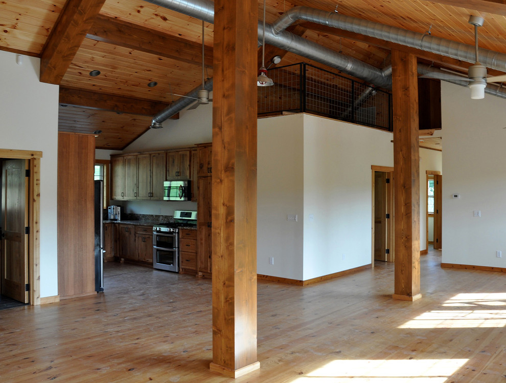 This is an example of a mid-sized country loft-style living room in Dallas with white walls and light hardwood floors.