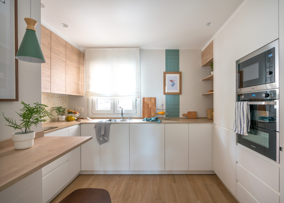 Design ideas for a small mediterranean u-shaped enclosed kitchen in Bilbao with a belfast sink, flat-panel cabinets, white cabinets, wood worktops, multi-coloured splashback, terracotta splashback, integrated appliances, ceramic flooring, no island, brown floors and brown worktops.