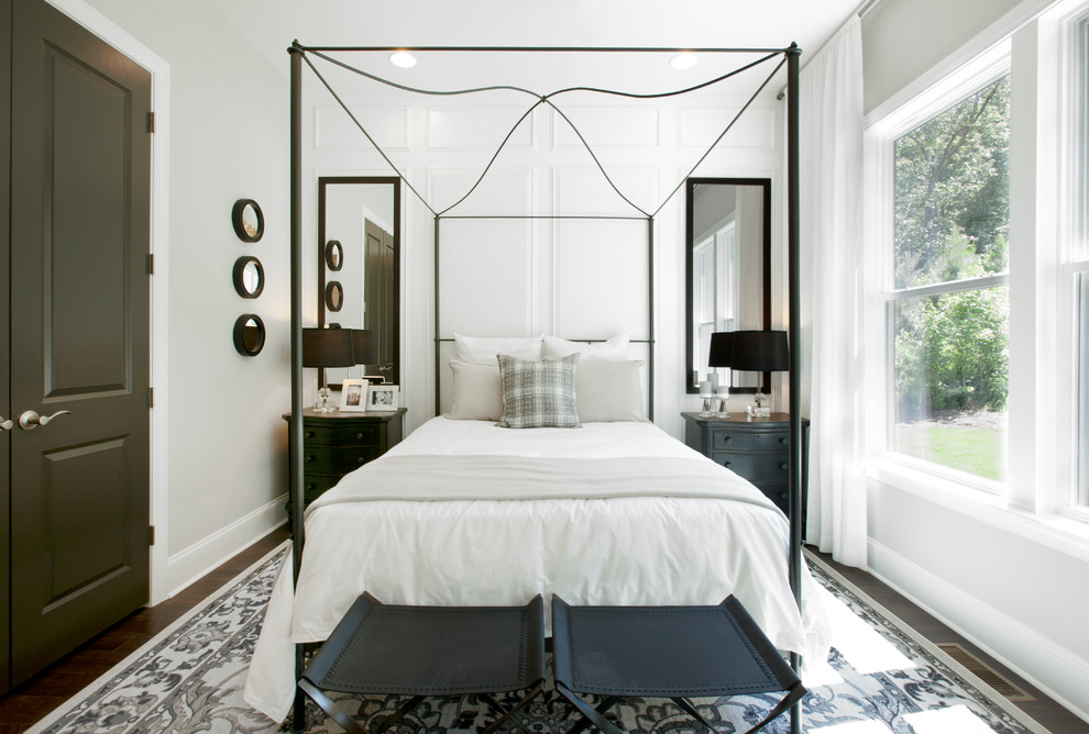 This is an example of a transitional bedroom in Atlanta with white walls, dark hardwood floors and no fireplace.