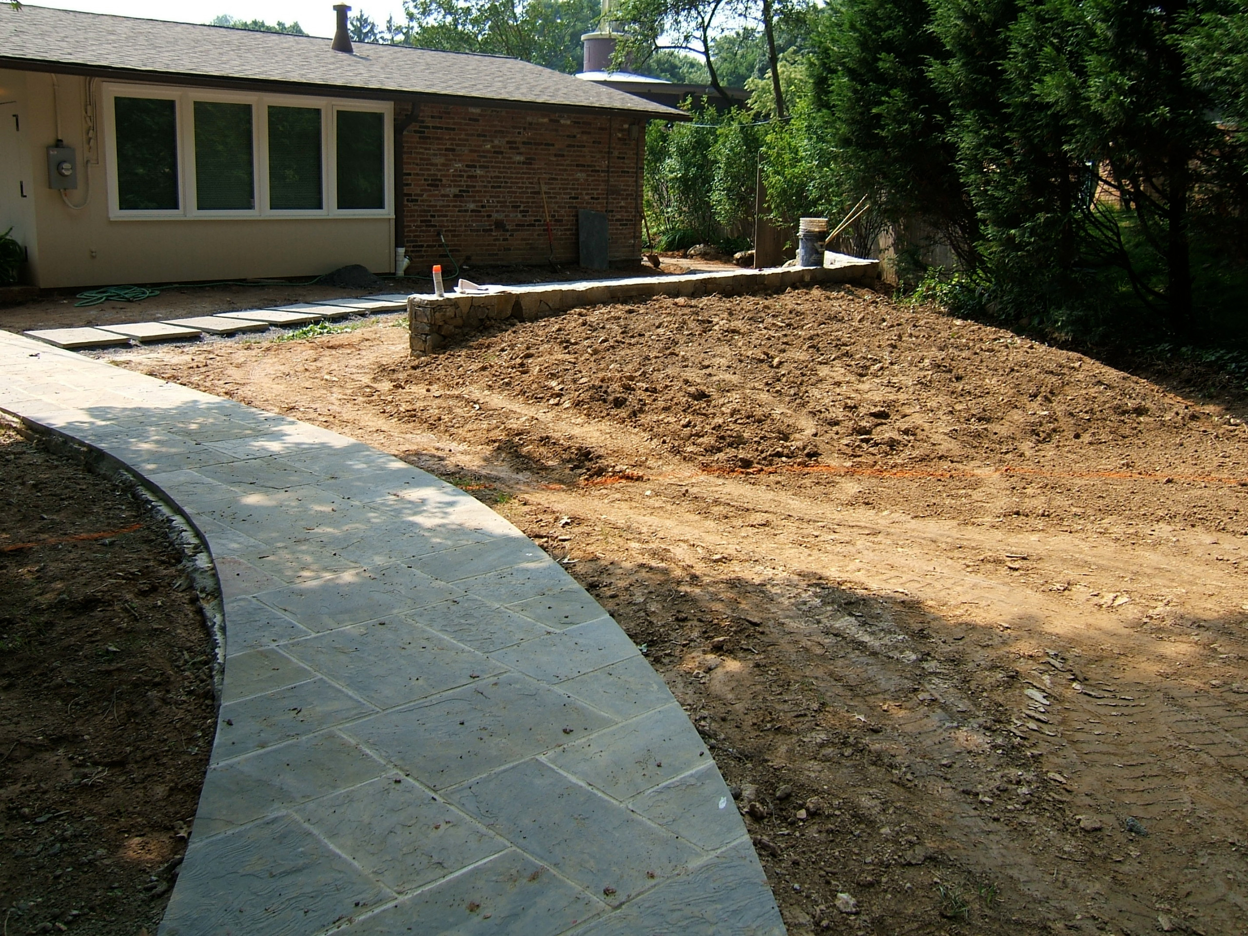 Curved lead walk, path to walled patio with privacy bern