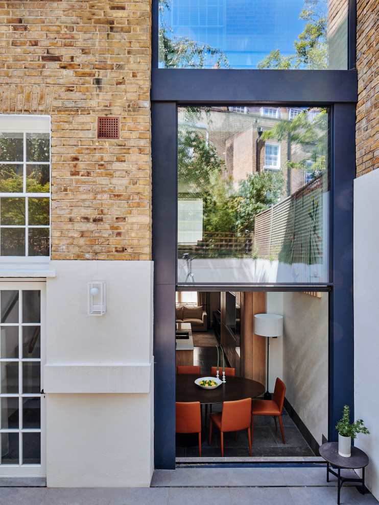 Inspiration for a large midcentury glass townhouse exterior in London with four or more storeys.