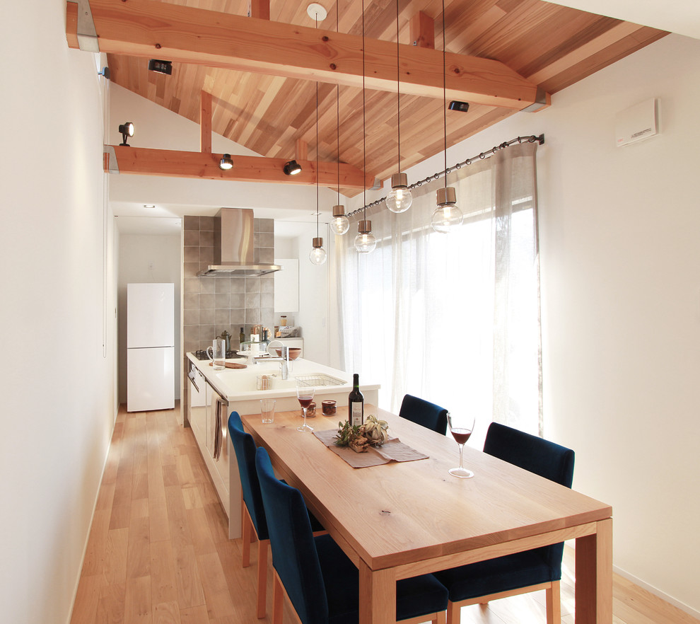 This is an example of an asian eat-in kitchen in Other with white cabinets, plywood floors and a peninsula.