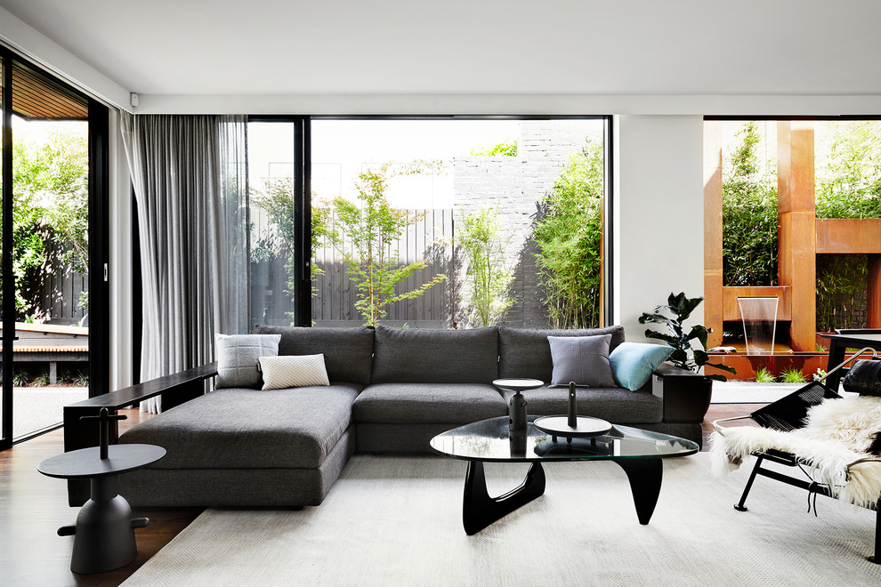 Photo of a contemporary open concept living room in Melbourne with white walls and dark hardwood floors.