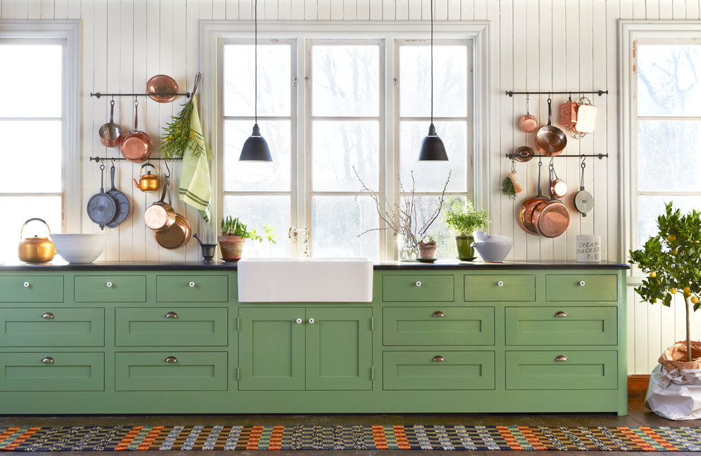 Inspiration for an expansive country single-wall kitchen in Stockholm with a farmhouse sink, shaker cabinets, green cabinets, dark hardwood floors, laminate benchtops and no island.