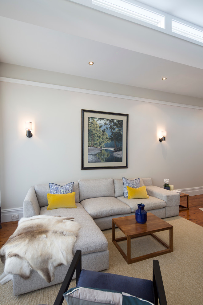 This is an example of a mid-sized transitional open concept living room in Sydney with white walls, medium hardwood floors, no fireplace and a wall-mounted tv.