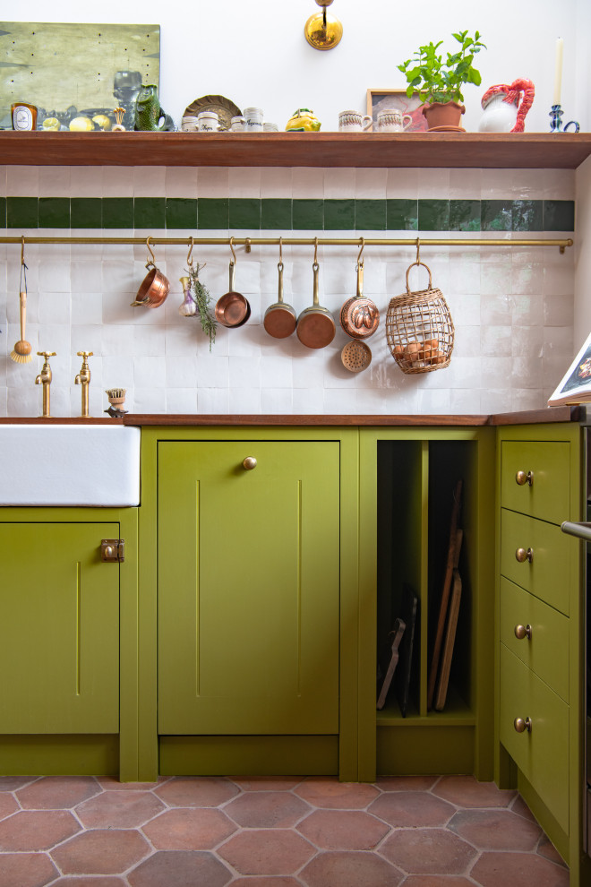 Inspiration för ett mellanstort funkis brun brunt kök, med en rustik diskho, gröna skåp, träbänkskiva, vitt stänkskydd, integrerade vitvaror och klinkergolv i terrakotta