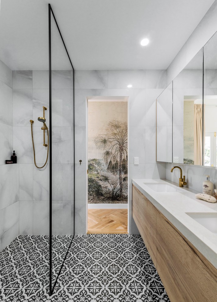 Beach style master bathroom in Brisbane with light wood cabinets, an open shower, white tile, ceramic tile, ceramic floors, an undermount sink, black floor, an open shower, white benchtops, flat-panel cabinets and grey walls.