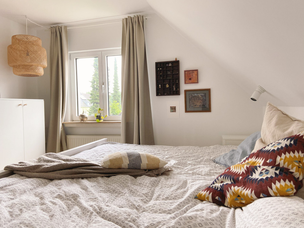 На фото: хозяйская спальня среднего размера на мансарде в скандинавском стиле с белыми стенами, паркетным полом среднего тона и коричневым полом с