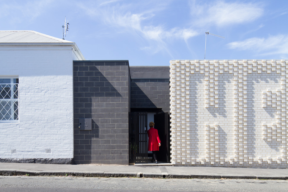 Small contemporary one-storey brick white exterior in Melbourne with a flat roof.
