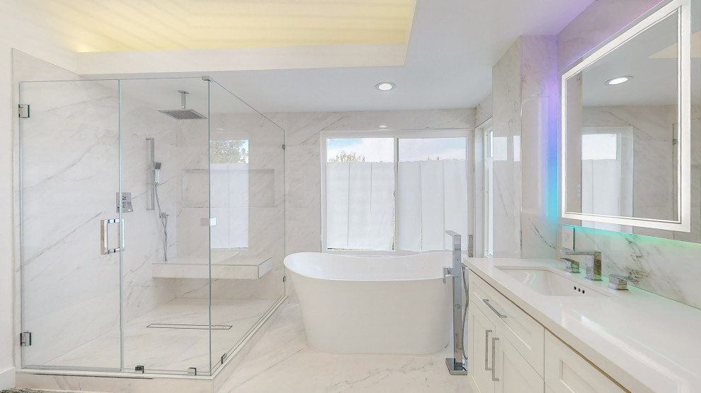 На фото: ванная комната в стиле модернизм с белыми фасадами, угловым душем, мраморной плиткой, разноцветными стенами, полом из терраццо, врезной раковиной, столешницей из кварцита, белой столешницей, нишей, тумбой под две раковины и встроенной тумбой